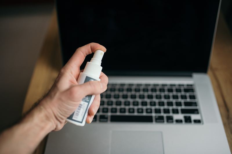 Person spraying cleaning solution onto a surface