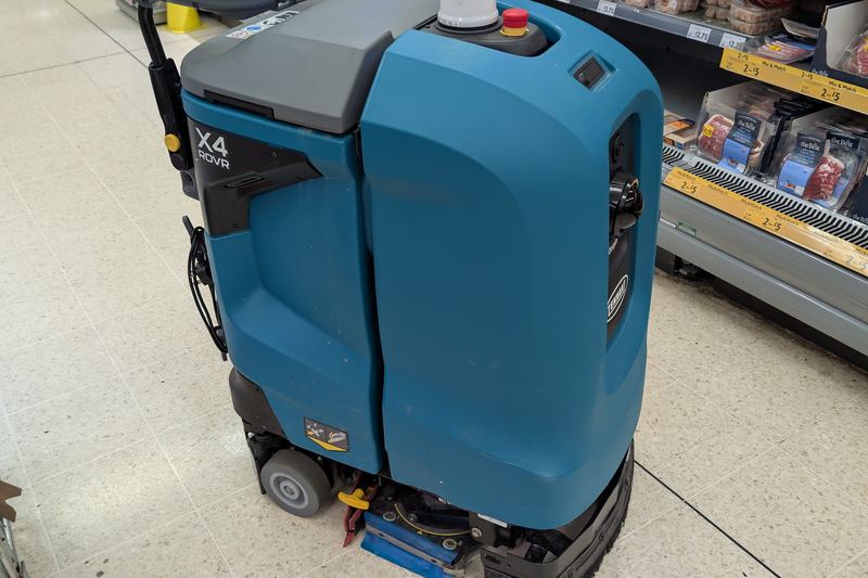 Autonomous floor scrubber operating in a retail aisle